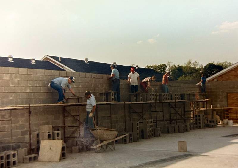 Church construction crew volunteers laying cinder blocks for walls during building expansion at Huber Heights Baptist Temple