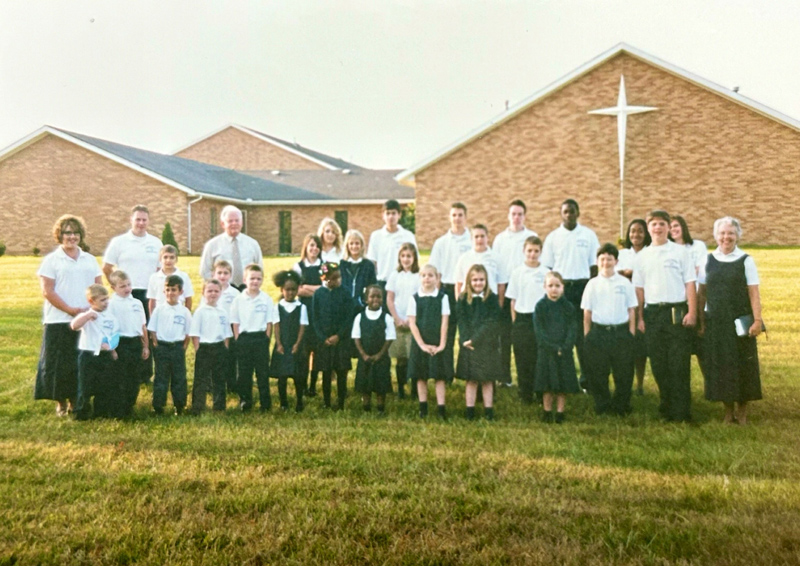 Huber Heights Christian Academy students posing in front of church building with teachers in background